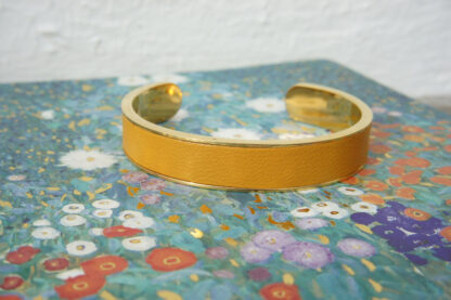 Bracelet manchette inox doré et cuir jaune moutarde incrusté.
